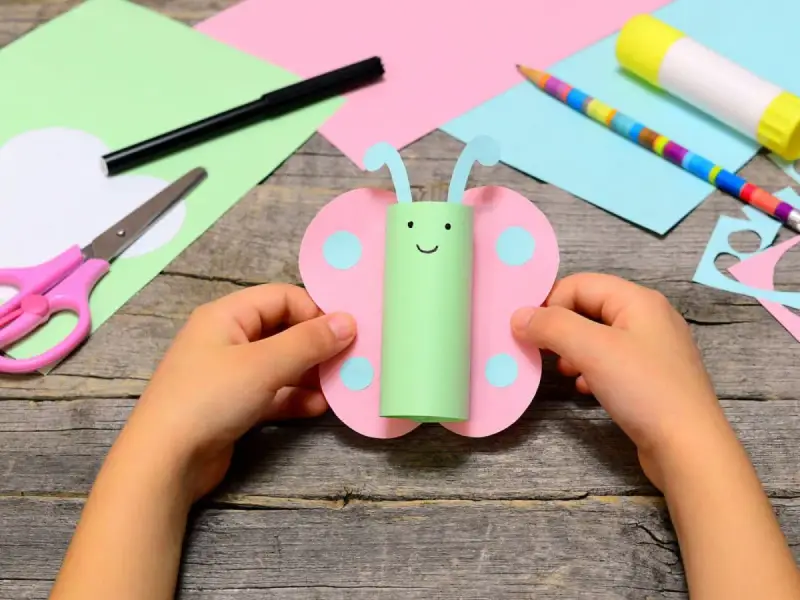 Un papillon en rouleau de papier toilette, un bricolage facile et rapide et utile. Des ciseaux, un crayon et de la colle sont à portée de main.